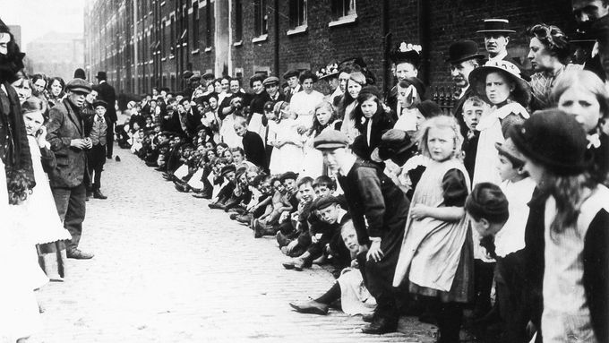 Na ilustrační fotografii z roku 1900 jsou londýnské děti stojící frontu na dřeváky.