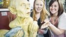 Visitors pose next to a sculpture of the J. R. R. Tolkien character Gollum at the Weta Cave museum in Wellington in this September 25, 2012 handout photograph. New Zealand's capital city was rushing to complete its transformation into a haven for hairy feet and pointed ears on November 27, 2012 as stars jetted in for the long-awaited world premiere of the first movie of the Hobbit trilogy. Picture taken September 25, 2012. REUTERS/Positively Wellington Tourism/Handout (NEW ZEALAND - Tags: ENTERTAINMENT SOCIETY) NO SALES. NO ARCHIVES. FOR EDITORIAL USE ONLY. NOT FOR SALE FOR MARKETING OR ADVERTISING CAMPAIGNS. THIS IMAGE HAS BEEN SUPPLIED BY A THIRD PARTY. IT IS DISTRIBUTED, EXACTLY AS RECEIVED BY REUTERS, AS A SERVICE TO CLIENTS Published: Lis. 27, 2012, 1:35 dop.