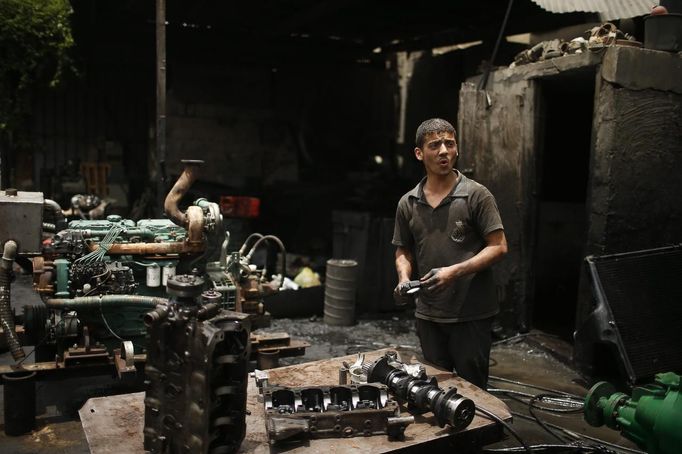 Palestinian Tamer Yassin, 17, works in a car repair garage in Gaza City May 30, 2013. Yassin left school to work as an apprentice in the garage so that he could support his family's income. Apprentice mechanics earn around $100 per month, garage owners said. REUTERS/Mohammed Salem (GAZA - Tags: TRANSPORT SOCIETY EMPLOYMENT) Published: Kvě. 30, 2013, 12:55 odp.