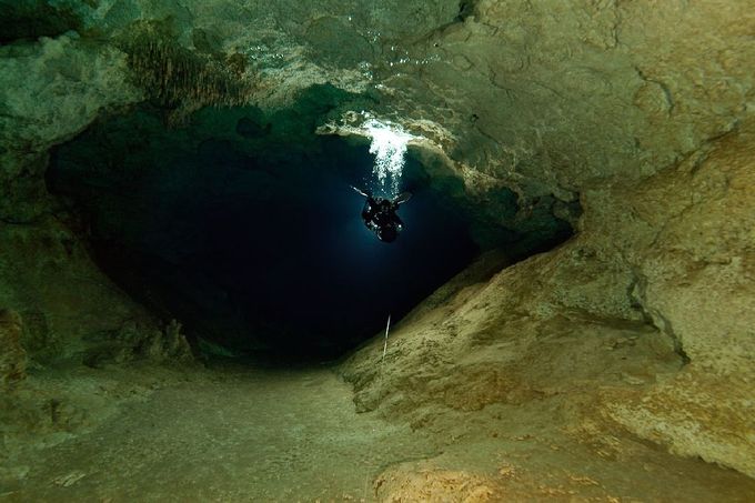 Gigantické chodby jeskynního systému K'oox Baal překonáváme pomocí podvodních skútrů.