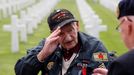 WWII veteran Norman Duncan salutes a comrade as he arrives for a ceremony at Normandy American Cemetery and Memorial situated above Omaha Beach