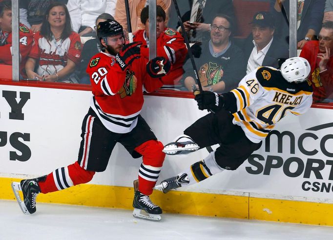 Chicago Blackhawks' Brandon Saad (L) checks Boston Bruins' David Krejci during the first period in Game 1 of their NHL Stanley Cup Finals hockey series in Chicago, Illino