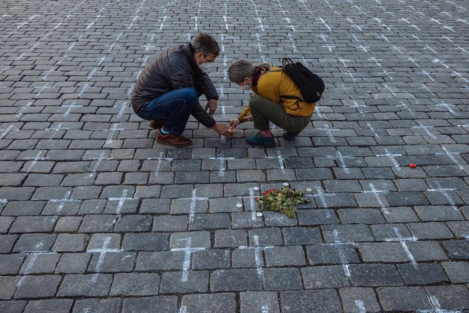 Lidé na Staroměstském náměstí v Praze spontánně uctívají oběti pandemie u křížů, které zde křídou nakreslila iniciativa Milion chvilek pro demokracii. 24 - 25. 3. 2021