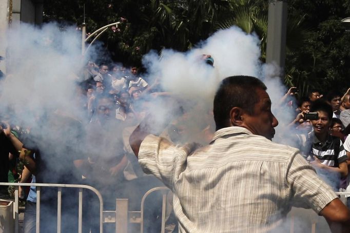 A demonstrator throws back a tear gas canister back to the police during a protest against Japan's decision to purchase disputed islands, which Japan calls the Senkaku and China calls the Diaoyu, in Shenzhen, south China's Guangdong province September 16, 2012. Torrid protests against Japan flared in Chinese cities for a second day on Sunday, with the government struggling to find a balance between venting public anger and containing violence that could backfire ahead of a delicate leadership succession. REUTERS/Tyrone Siu (CHINA - Tags: POLITICS CIVIL UNREST)