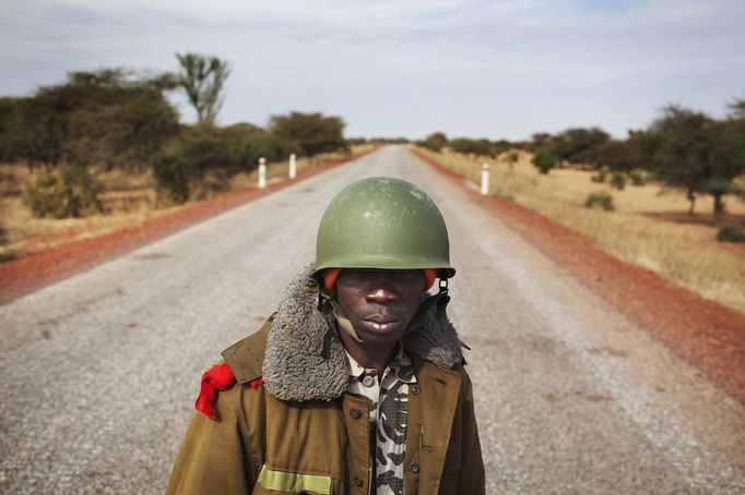 Malian soldier Ousmane Cisse stands guard on an open road outside Sevare, Mali, January 27, 2013. REUTERS/Joe Penney (MALI - Tags: MILITARY POLITICS CONFLICT TPX IMAGES OF THE DAY) Published: Led. 27, 2013, 4:40 odp.