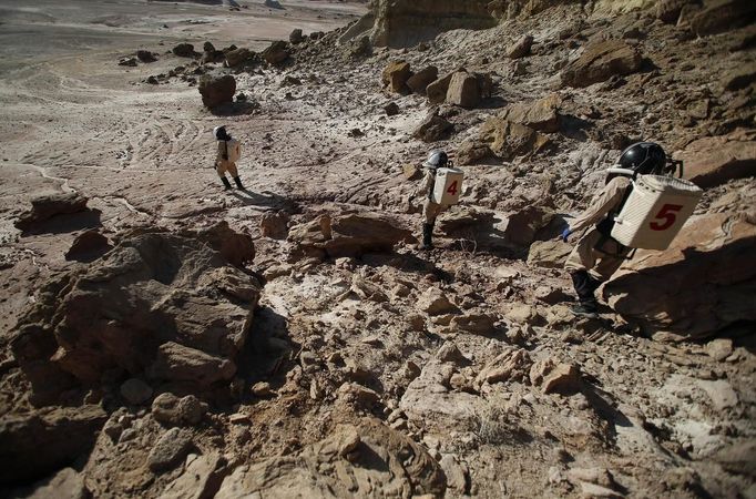 Members of Crew 125 EuroMoonMars B mission venture out in their simulated spacesuits to collect geologic samples for study at the Mars Desert Research Station (MDRS) in the Utah desert March 2, 2013. The MDRS aims to investigate the feasibility of a human exploration of Mars and uses the Utah desert's Mars-like terrain to simulate working conditions on the red planet. Scientists, students and enthusiasts work together developing field tactics and studying the terrain. All outdoor exploration is done wearing simulated spacesuits and carrying air supply packs and crews live together in a small communication base with limited amounts of electricity, food, oxygen and water. Everything needed to survive must be produced, fixed and replaced on site. Picture taken March 2, 2013. REUTERS/Jim Urquhart (UNITED STATES - Tags: SCIENCE TECHNOLOGY SOCIETY ENVIRONMENT) ATTENTION EDITORS: PICTURE 19 OF 31 FOR PACKAGE 'MARS IN THE DESERT' SEARCH 'JIM MARS' FOR ALL IMAGES Published: Bře. 11, 2013, 2:06 odp.