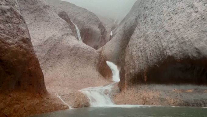 Smrtící vedro vystřídal vzácný jev. Po slavné skále Uluru se valily kaskády vody.