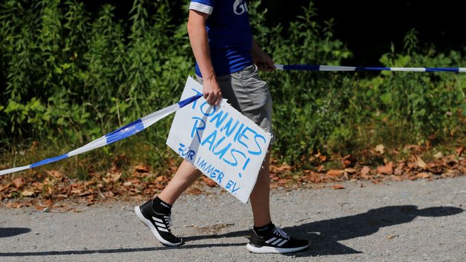 Fanoušek Schalke 04 s transparentem, který vyzývá k odchodu šéfa klubu Clemense Tönniese.