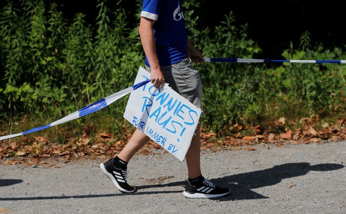 Fanoušek Schalke 04 s transparentem, který vyzývá k odchodu šéfa klubu Clemense Tönniese.