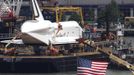 Space Shuttle Enterprise is seen from Weehawken, New Jersey, as it is fastened to a crane before being lifted onto the deck of the Intrepid Sea, Air & Space Museum in New York, June 6, 2012. REUTERS/Gary Hershorn (UNITED STATES - Tags: SCIENCE TECHNOLOGY TRANSPORT CITYSPACE) Published: Čer. 6, 2012, 8:48 odp.