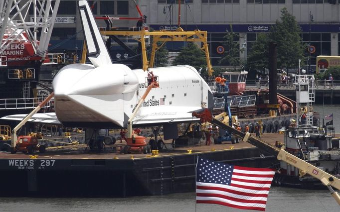 Space Shuttle Enterprise is seen from Weehawken, New Jersey, as it is fastened to a crane before being lifted onto the deck of the Intrepid Sea, Air & Space Museum in New York, June 6, 2012. REUTERS/Gary Hershorn (UNITED STATES - Tags: SCIENCE TECHNOLOGY TRANSPORT CITYSPACE) Published: Čer. 6, 2012, 8:48 odp.