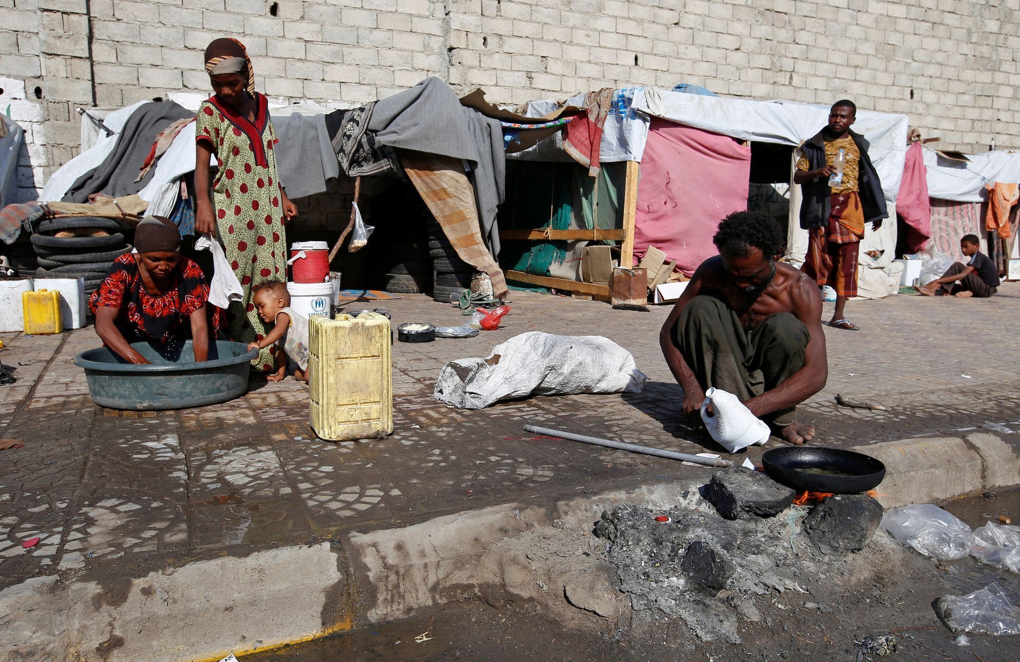 Lidé vysídlení válkou v severozápadních oblastech Jemenu u svých provizorních obydlí v přístavním městě Hodeida