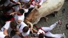 Runners are knocked down by steers at the entrance to the bullring during the first running of the bulls of the San Fermin festival in Pamplona July 7, 2012. One person was gored and four others injured in a run by Dolores Aguirre fighting bulls that lasted two minutes and fifty-two seconds, according to local media. Steers are used to guide the bulls and round up any that are divided from the pack of six. REUTERS/Vincent West (SPAIN - Tags: ANIMALS SOCIETY) Published: Čec. 7, 2012, 8:26 dop.