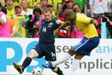 Brazilec Adriano (ve žlutém) dává gól do sítě Austrálie. Nezabránil mu v tom ani Scott Chipperfield.