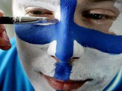 Finský fanoušek v národních barvách se připravuje na zápas s Českem. Hokej patří ve Finsku k národním sportům.
