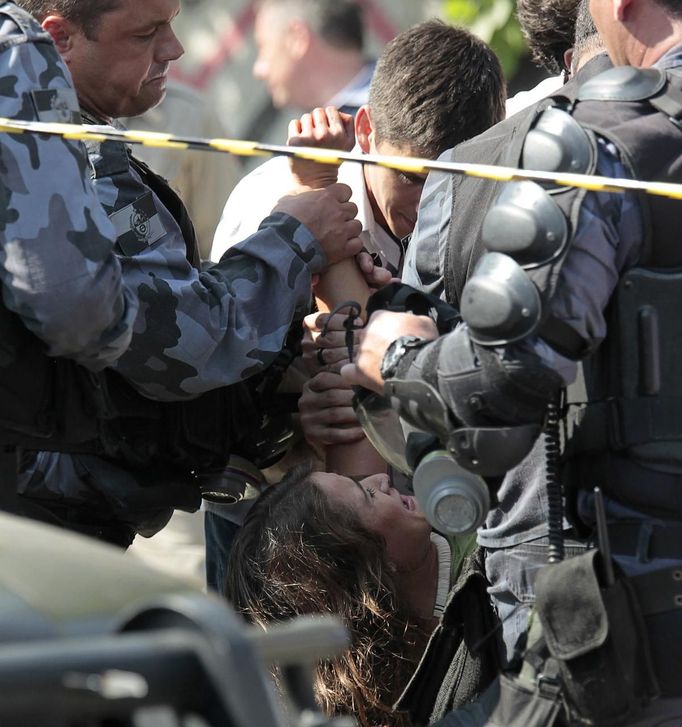 A supporter of native Indians is arrested during protests in front of the Brazilian Indian Museum in Rio de Janeiro, March 22, 2013. Brazilian military police took position early morning outside the Indian museum, where a native Indian community of around 30 individuals who have been living in the abandoned Indian Museum since 2006. Indians were summoned to leave the museum in 72 hours by court officials since last week, local media reported. The group is fighting against the destruction of the museum, which is next to the Maracana Stadium. REUTERS/Sergio Moraes (BRAZIL - Tags: POLITICS CIVIL UNREST) Published: Bře. 22, 2013, 5:44 odp.