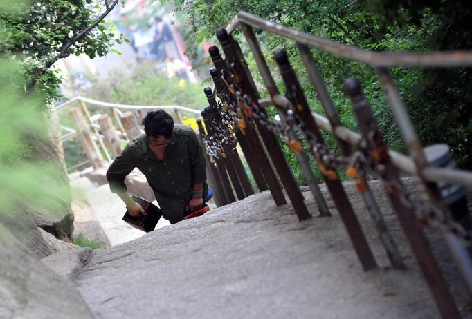 HUAYIN, CHINA - AUGUST 13: (CHINA OUT) Legless man Chen Zhou climbs the Huashan Mountain on August 13, 2012 in Huayin, Shaanxi Province of China. Legless 29-year-old man Chen Zhou from Cangshan of Shandong Province spent two days, 19 hours in total, climbing by arms to the top of Huashan Mountain. Chen lost his legs after falling off a train at the age of 13, but he has since strived to be stronger and joined in many public performances to encourage other people. Chen Zhou will climb the Taishan Mountain in Shandong province in the following months. ( automatický překlad do češtiny )