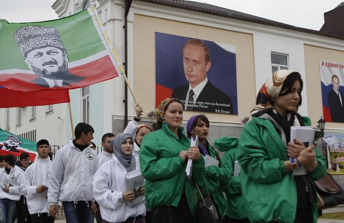 Members of a youth club supporting former Chechen leader Akhmad Kadyrov (printed on flag) march along a street during a rally in the centre of the Chechen capital Grozny April 25, 2013. The naming of two Chechens, Dzhokhar and Tamerlan Tsarnaev, as suspects in the Boston Marathon bombings has put Chechnya - the former site of a bloody separatist insurgency - back on the world's front pages. Moscow has poured billions of roubles into rebuilding Chechnya, a mainly Muslim province that has seen centuries of war and repression. Picture taken April 25, 2013. REUTERS/Maxim Shemetov (RUSSIA - Tags: SOCIETY POLITICS RELIGION) ATTENTION EDITORS: PICTURE 12 OF 40 FOR PACKAGE 'INSIDE MODERN CHECHNYA'. SEARCH 'REBUILDING CHECHNYA' FOR ALL IMAGES Published: Kvě. 1, 2013, 7:42 dop.