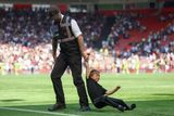 Hlídač fotbalového stadionu v britském Southamptonu vyvádí z hřiště mladého fanouška, který na trávník vběhl po konci zápasu.