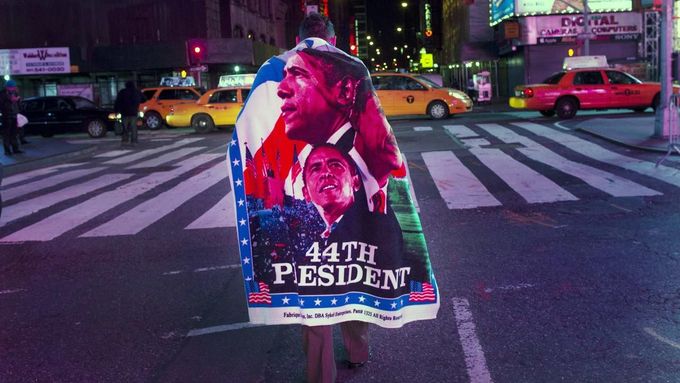Muž s plakátem na zádech oslavuje výhru Baracka Obamy na Times Square v New Yorku.