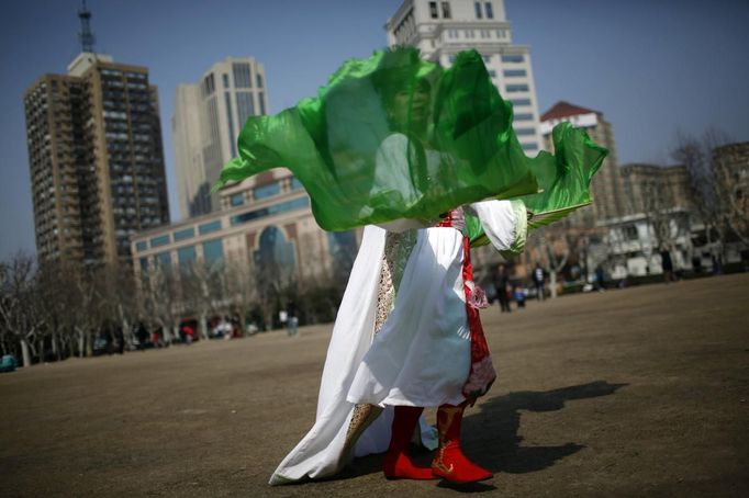 Xiao Cao, a 57-year-old gay man, performs as an ancient Chinese fairy at Fuxing park in Shanghai March 13, 2012. China's gay community has long been on the edges of society but it is gradually becoming more accepted. Cao, who is an unemployed drag queen, is one whose life lifts the curtain on a less romanticised view of Chinese homosexuals. Living in an eight-square-metre apartment behind a public toilet and with a monthly income of 500 yuan ($79) from social insurance, he passes his days dancing in public and spending time with friends at gay clubs. Picture taken March 13, 2012. REUTERS/Aly Song (CHINA - Tags: SOCIETY) CHINA OUT. NO COMMERCIAL OR EDITORIAL SALES IN CHINA. ATTENTION EDITORS PICTURE 17 OF 28 OF PACKAGE 'GAY AND OUT IN CHINA' TO FIND ALL IMAGES SEARCH 'GAY OUT CHINA' Published: Čer. 1, 2012, 12:39 dop.