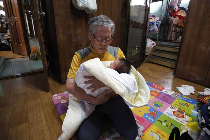 South Korean pastor Lee Jong-rak holds an abandoned baby boy as he prays at Joosarang church in Seoul September 18, 2012. The South Korean pastor who runs a "baby box" where mothers can leave unwanted infants has seen a sharp increase in the number of newborns being left there because, the pastor says, of a new law aimed protecting the rights of children. South Korea is trying to shed a reputation of being a source of babies for adoption by people abroad. It is encouraging domestic adoption and tightening up the process of a child's transfer from birth mother to adoptive parents. Picture taken September 18, 2012. REUTERS/Kim Hong-Ji (SOUTH KOREA - Tags: SOCIETY) Published: Říj. 7, 2012, 6:47 dop.