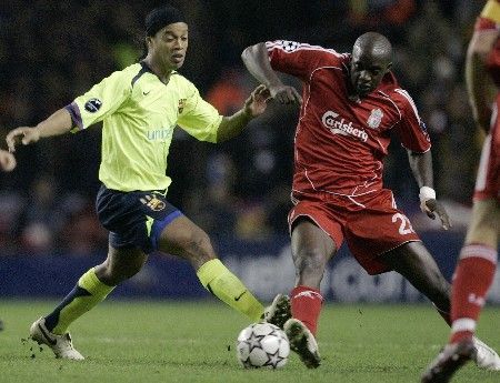 Barcelonský Ronaldinho (vlevo) atakuje Moma Sissoka z Liverpoolu v odvetě osmifinále Ligy mistrů.