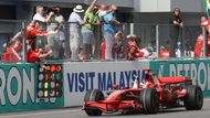 Kimi Räikkönen s Ferrari zajíždí k mechaniků a oslavuje prvenství v Malajsii.