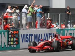 Kimi Räikkönen s Ferrari zajíždí k mechaniků a oslavuje prvenství v Malajsii.