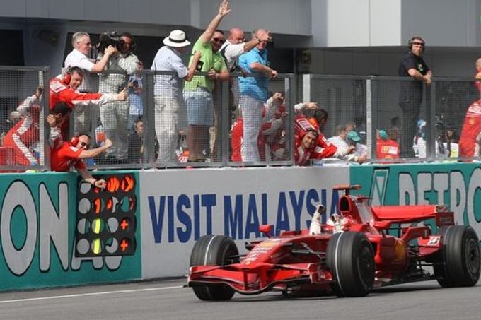Kimi Räikkönen s Ferrari zajíždí k mechaniků a oslavuje prvenství v Malajsii.