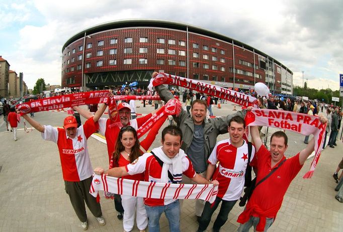 Fanoušci - tři generace rodiny Sochrů ze Žižkova - před novou arénou Slavie. Starý stadion z roku 1953 byl zbourán v březnu 2004, ten nový se začal stavět na podzim roku 2006.