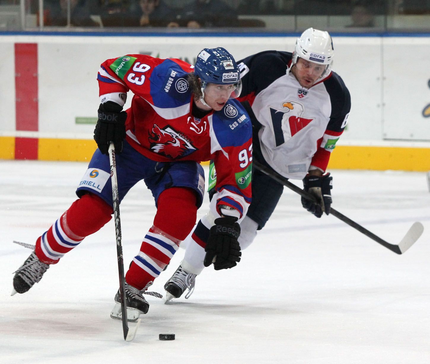 Hokejista Lva Praha Jakub Voráček v souboji s Jánem Tabačkem v utkání KHL 2012/13 proti Slovanu Bratislava.