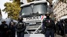Francouzská pořádková policie stojí v pozici před vozidlem s vodním dělem během demonstrace v Paříži v rámci celonárodní stávky.