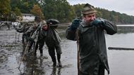 Několik desítek rybářů v sychravém a šedivém podzimním ránu po východu slunce zatáhlo v upuštěném rybníku za sítě, v nichž uvízly první ryby. Výlov Rožmberka, rozlohou největšího rybníka v Česku; 17. října 2025.