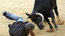 Reuters photographer Joseba Etxaburu is knocked down by a wild cow during festivities in the bullring following the sixth running of the bulls of the San Fermin festival in Pamplona July 12, 2012. Etxaburu suffered some scratches on his right elbow but was able to continue shooting afterwards. REUTERS/Susana Vera (SPAIN - Tags: SOCIETY ANIMALS) Published: Čec. 12, 2012, 9:49 dop.