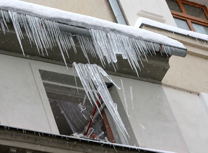 Aby nepadaly také metrové rampouchy ze třetího patra domu Moskevské ulice, je nutné je řízeně srazit k zemi dobře mířeným úderem smetáku.