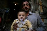 Otec s dítětem. Ve svém obchodu dlouho nic neprodal. Z Aleppa už utekly desetitisíce lidí. Statisíce lidí, kteří zůstali, se snaží přežít.