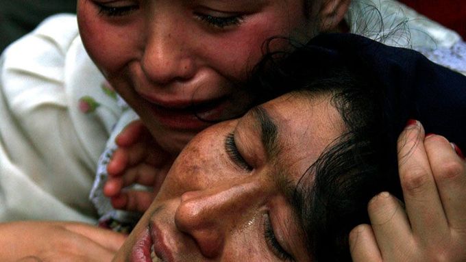 Žena a její dcera pláčí během protestů v Urumči.