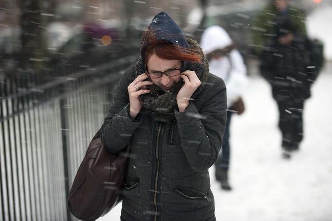 A woman makes her way through snow and wind in New York, February 8, 2013. A blizzard blew into the northeastern United States on Friday, cutting short the workweek for millions who feared being stranded as state officials ordered roads closed ahead of what forecasters said could be record-setting snowfall. From New York to Maine, the storm began gently, dropping a light dusting of snow, but officials urged residents to stay home, rather than risk getting stuck in deep drifts when the storm kicks up later Friday afternoon. REUTERS/Keith Bedford (UNITED STATES - Tags: ENVIRONMENT) Published: Úno. 9, 2013, 12:30 dop.