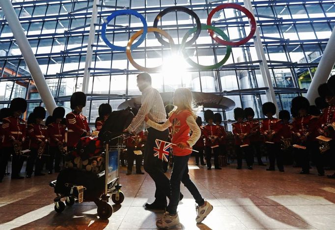 Travellers pass the Olympic Rings during an unveiling ceremony in the Terminal Five arrivals hall at Heathrow Airport, in preparation for the London 2012 Olympic Games in London June 20, 2012. REUTERS/Luke MacGregor (BRITAIN - Tags: TRANSPORT SOCIETY SPORT OLYMPICS) Published: Čer. 20, 2012, 9:54 dop.