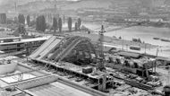 Rok 1963. Dobový popisek: "V Praze v Podolí budují pracovníci Vodních staveb Sezimovo Ústí moderní plavecký stadion. Otevřené bazény - plavecký dlouhý 50 m a 30 m široký a skokanský 30 x 30 m, byly prakticky dokončeny v roce 1960. Nyní se staví krytá hala, v níž bude další 50metrový bazén a hlediště se sedadly pro diváky."