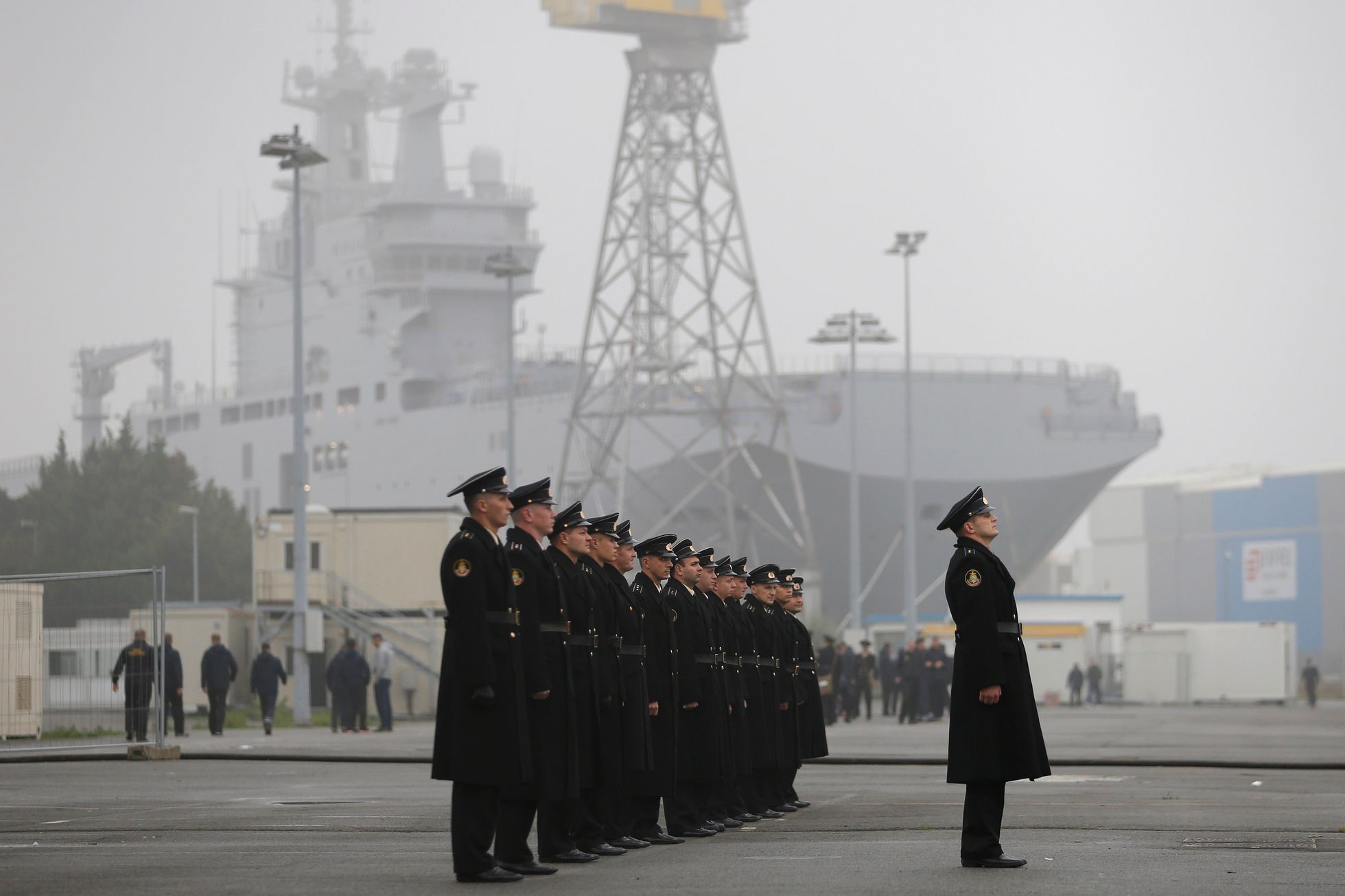 Russian sailors stand in formation in front of the Mistral-class helicopter carrier Vladivostok at the STX Les Chantiers de l'Atlantique shipyard site in Saint-Nazaire