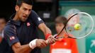 Srbský tenista Novak Djokovič odráží míček na Itala Andrease Seppiho během osmifinálového utkání French Open 2012.