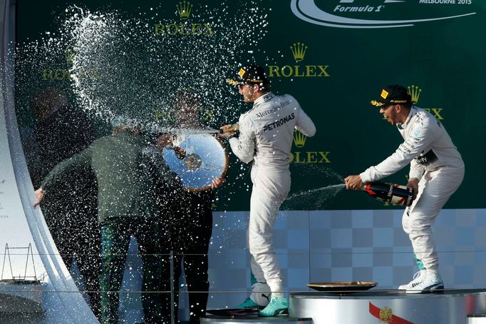 Mercedes Formula One driver Nico Rosberg of Germany (C) and team mate Lewis Hamilton of Britain (R) spray champgane at F1 legend Jackie Stewart during the podium ceremony