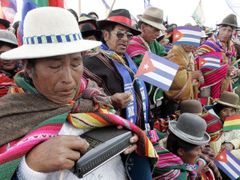 Bolívijská žena ladí rádio, když čeká spolu s tisíci příznivci prezidenta Moralese na zahájení obřadu v Tiwanaku.