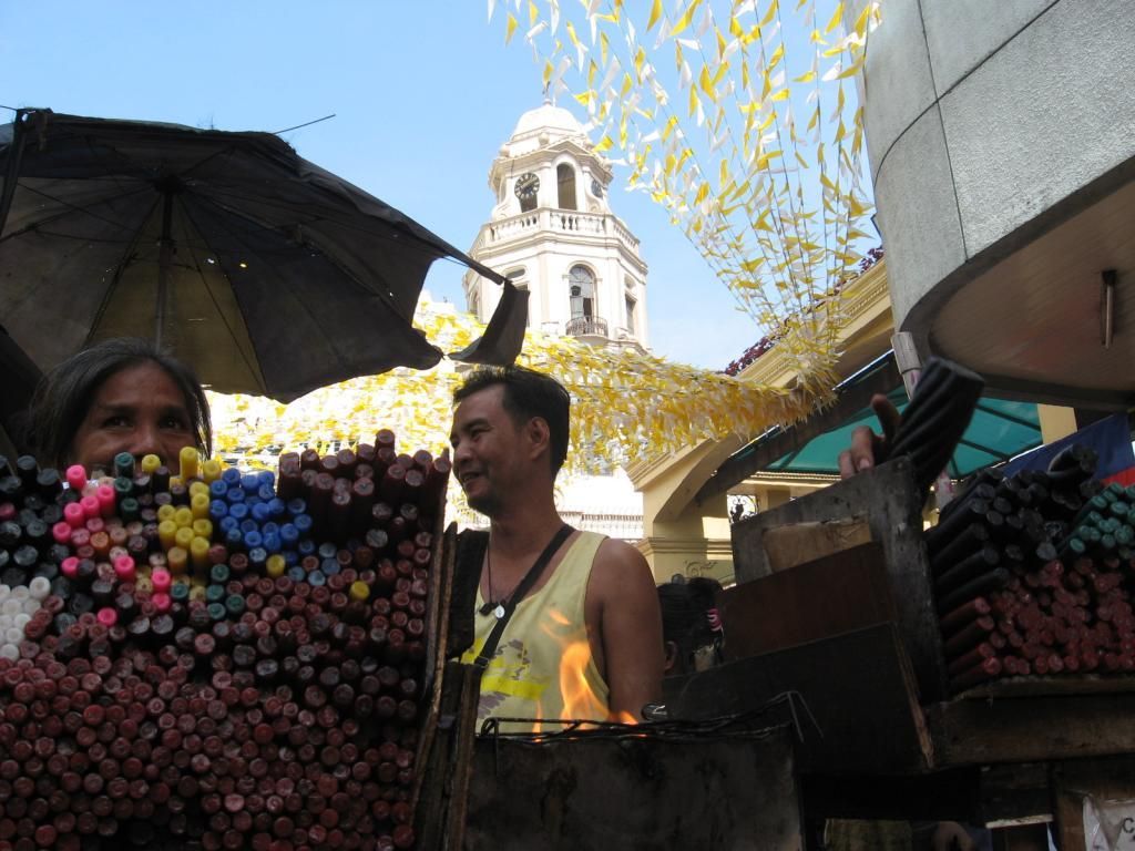 Prodavači svíček před kostelem v Manile