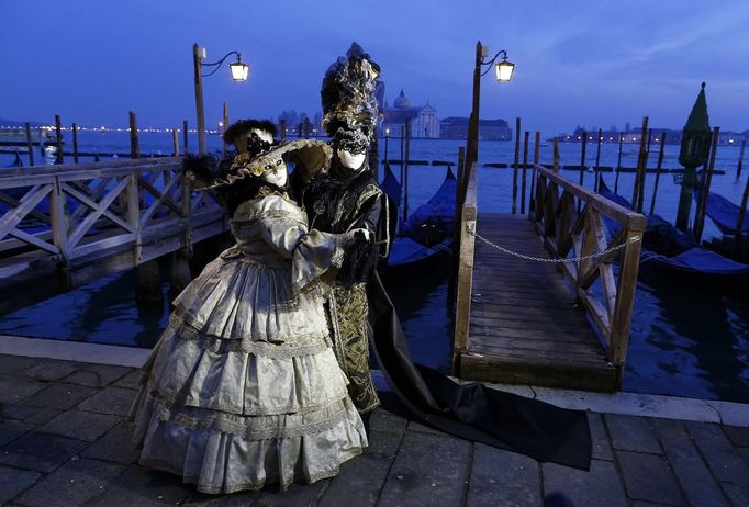 Marco Dilauro and his wife Nadia, wearing costumes, pose at San Marco square during the Venice Carnival January 25, 2013. Marco Dilauro, 43, is a tax collector by day, but his real passion is making masks and costumes for the carnival. A resident of Como, northern Italy, he chooses fabrics, ribbons, lace and costume jewellery to make the period costumes after doing extensive research, and wears them at Carnival, which ends on the day before Ash Wednesday. Picture taken January 25, 2013. REUTERS/Alessandro Bianchi (ITALY - Tags: SOCIETY) Published: Led. 28, 2013, 1:35 dop.