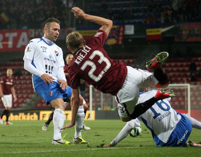 Fotbalista Sparty Praha Ladislav Krejčí padá po zákroku Jana Zawady před Vladanem Milosavljevem v utkání 10. kola Gambrinus ligy 2012/13 proti Baníku Ostrava.