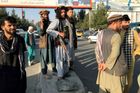 Člen Tálibánu (uprostřed) stojí před letištěm v Kábulu.