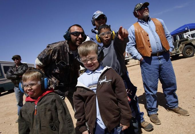 Spectators watch as shooters fire their weapons during the Big Sandy Shoot in Mohave County, Arizona March 23, 2013. The Big Sandy Shoot is the largest organized machine gun shoot in the United States attended by shooters from around the country. Vintage and replica style machine guns and cannons are some of the weapons displayed during the event. Picture taken March 22, 2013. REUTERS/Joshua Lott (UNITED STATES - Tags: SOCIETY) Published: Bře. 25, 2013, 3:35 odp.